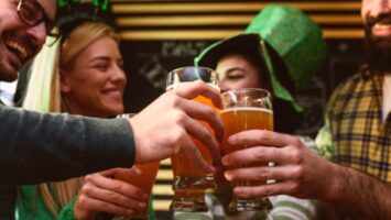Friends dressed in St. Patrick's Day garb toasting beers