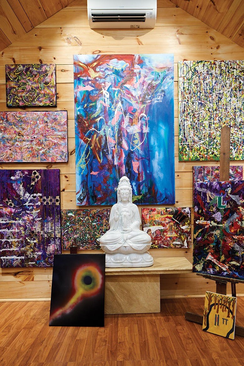 Inside, a Buddhist statue sits surrounded by Kathleen's paintings.