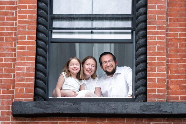 A family with their tween daughter captured from the window of their Hoboken brownstone