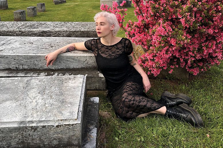 Woman in black dress in graveyard