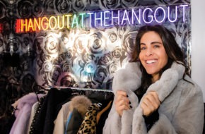 Lauren Turk tries on a fur coat at the Hangout, her Englewood consignment shop.