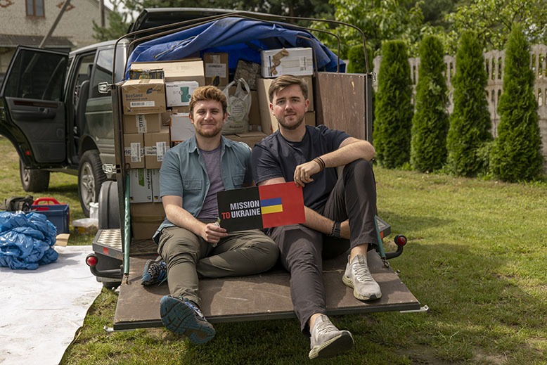 Dillon Carroll of Ridgewood and Mark Kreynovich sit in front of a car loaded with supplies for their newly formed organization, Mission to Ukraine