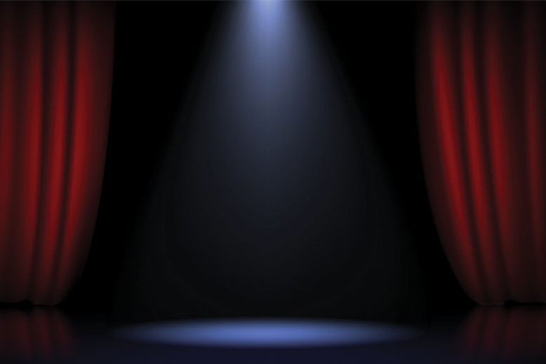 Theater stage with red curtains and spotlight