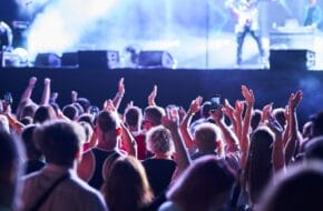 Guests at nighttime concert with their hands raised