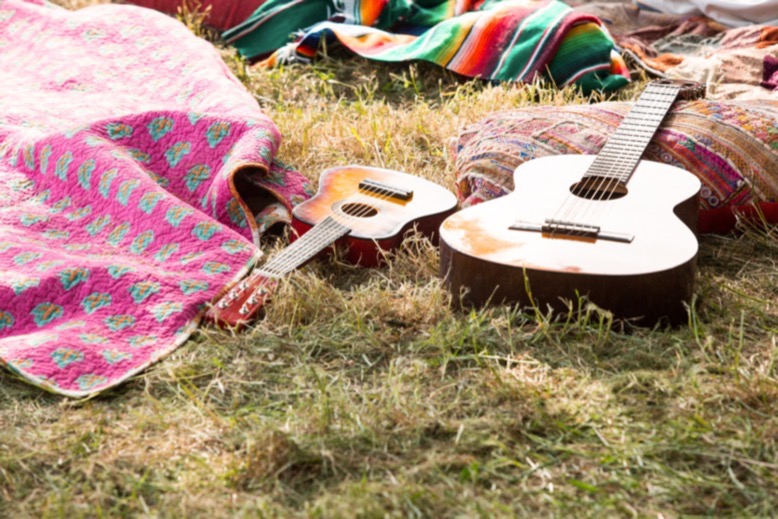 Guitars on grass amid colorful blankets and pillows