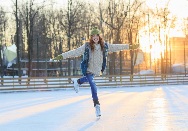 A girl ice skates outside.