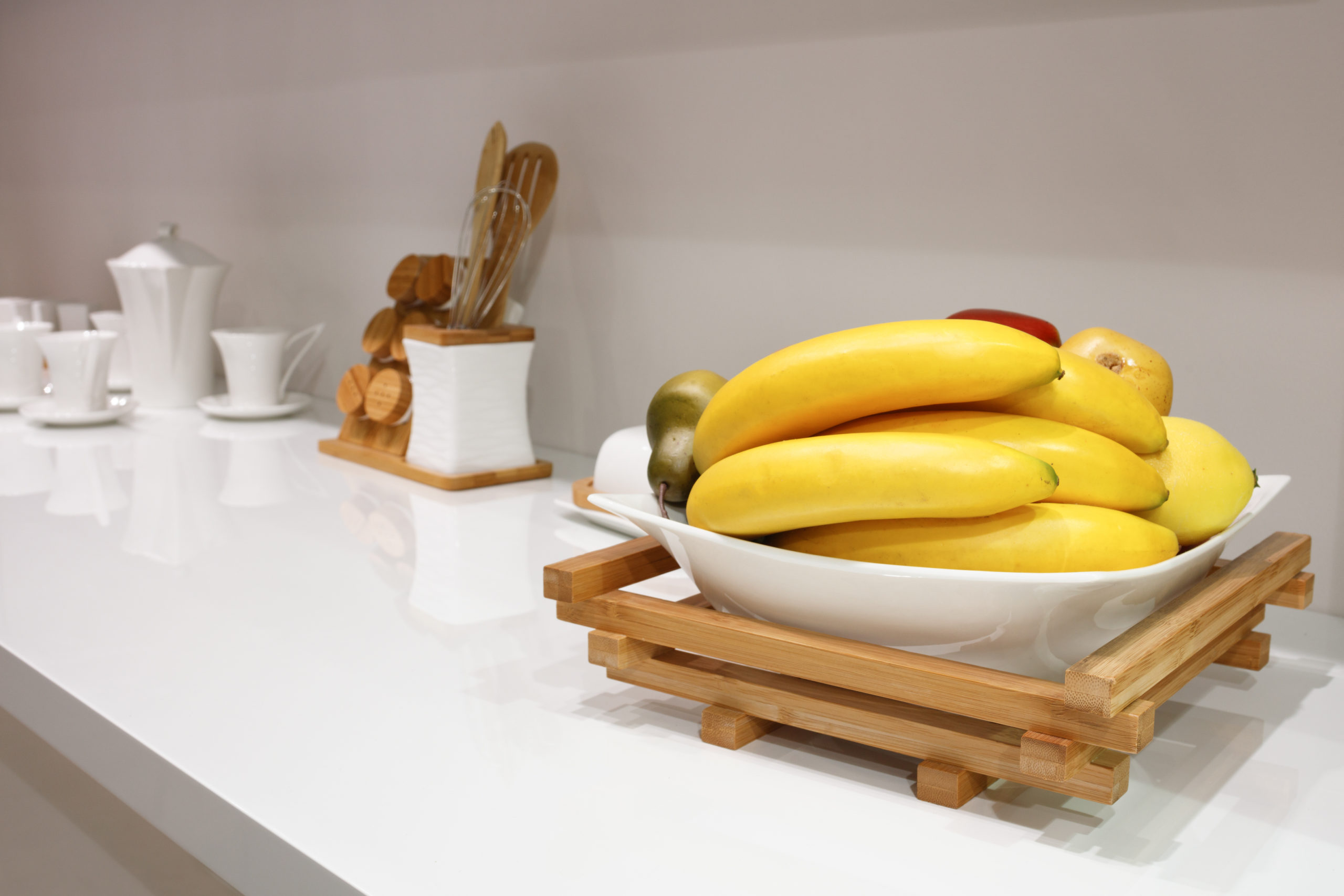 Bananas pop in a white kitchen.