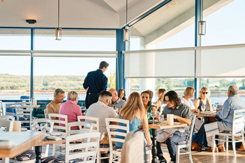 Patrons and a server in the Lookout's dining room, which boasts a panoramic view of the Delaware Bay