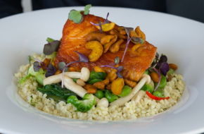 Seared Scottish salmon over spring vegetables, herbed bulgar and Asian broth, with tumeric-coated cashews.