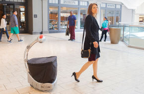 Five Elements Robotics CEO Wendy Roberts leads a loyal Budgee around Short Hills Mall.
