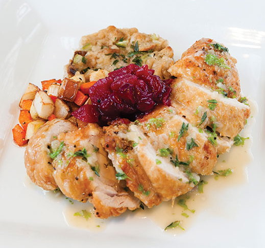 Chicken roulade with stuffing soufflé, root vegetables and chipotle-cranberry sauce.