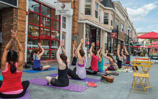 The Division Street pedestrian plaza in Somerville hosts a farmers' market and gatherings like this yoga class.