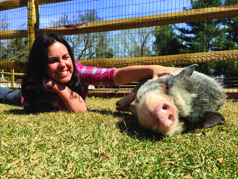 Pugsley, a pot-bellied pig, enjoys a little attention from Tracey Stewart at Bufflehead Farm in Middletown.