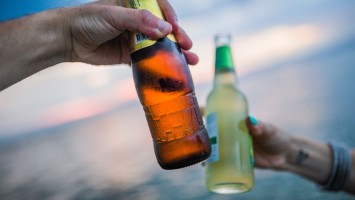 two bottles toasting on beach