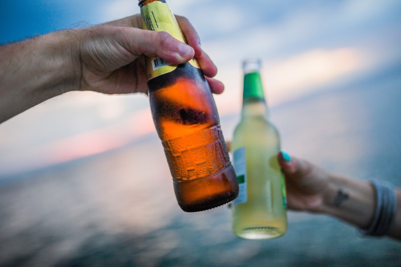 two bottles toasting on beach