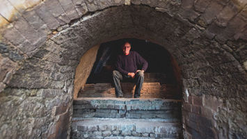 Bruce Dehnert, head of ceramics at Peters Valley, sits inside the craft school's 46-foot-long Anagama kiln.