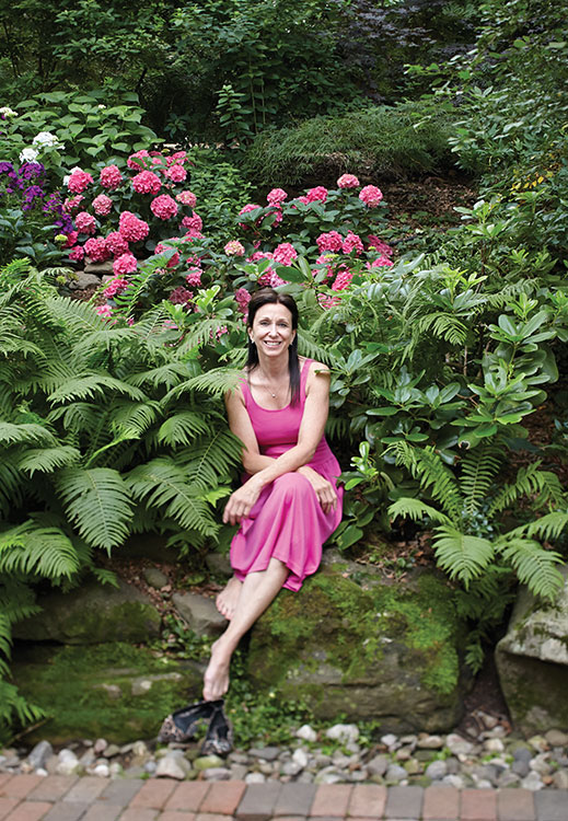 Master Gardener Caroline Yourcheck sits among hundreds of shade-tolerant hydrangeas.