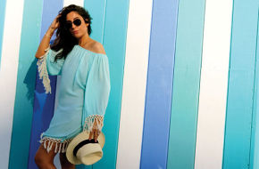 Nikki Tans owner Nicole Tocci in an aqua, fringed cover-up and straw fedora from the shop's vacation-inspired collections.