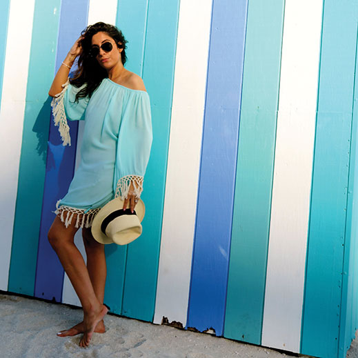 Nikki Tans owner Nicole Tocci in an aqua, fringed cover-up and straw fedora from the shop's vacation-inspired collections.