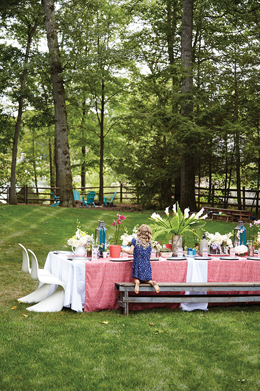 Bella Levison sets the table for a dinner gathering in her family’s spacious Franklin Lakes backyard.