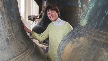 Lisa Lonie stands near the largest bells in Grover Cleveland Tower. When played each Sunday at 1 p.m., the music can be heard up to a mile away.