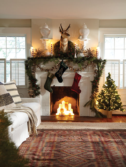 One of the home’s two fireplaces is aglow with lit candles. The mostly white palette is consistent throughout the house.