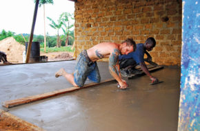 Mike Pond and one of his veteran Liberian crew trowel a concrete floor.