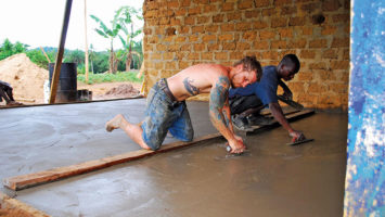 Mike Pond and one of his veteran Liberian crew trowel a concrete floor.