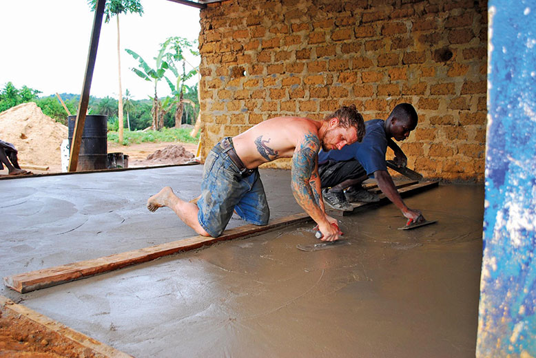 Mike Pond and one of his veteran Liberian crew trowel a concrete floor.