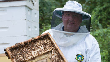 Apiarist Frank Mortimer works his hives in Upper Saddle River. Mortimer had never been around a beehive before he started keeping bees in 2007.