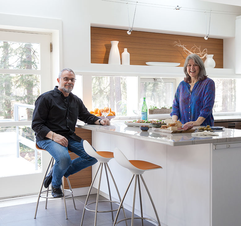 Fran and Richard in their renovated kitchen. The couple kept the layout but upgraded all the materials. The shelf nook above the window is original.