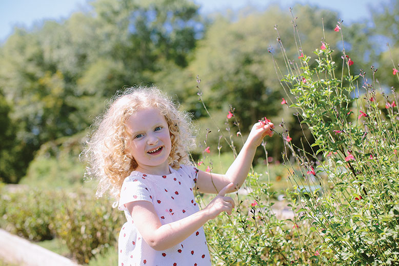 Bette Helfstein of Manhattan finds joy amid the herbs and flowers on her family’s visit to the farm.