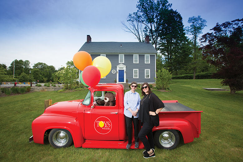 Toys With Love mother/daughter team Gail Rogers, left, and Stacey Rogers with their 1956 delivery truck outside the 1770s farmhouse that serves as their shop.