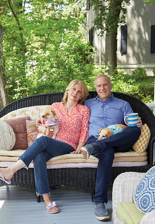 Surrounded by reclaimed outdoor decor, Susan and Bob Bush chill out on their whimsical front porch.