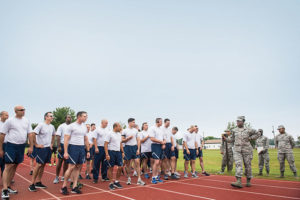 An officer briefs Air National Guard trainees on their fitness goals before they take another trip around the track.