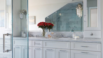 Passanante chose stainless fixtures and hardware to add a touch of sparkle to the room. The custom mirror reflects the entire space, making the room appear larger than it is.