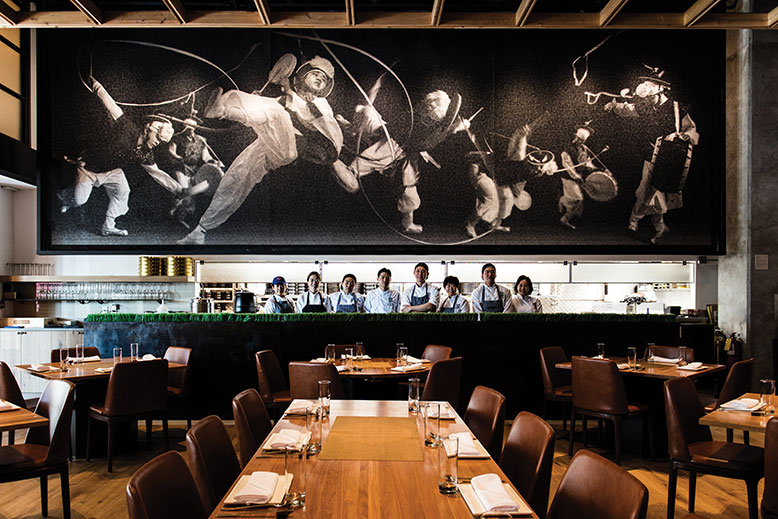 The Korean restaurant's kitchen team stands under a mural commissioned by owner Andy Sung, an architect who designed the spacious, elegant establishment.