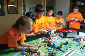 Anna Heinrich, left, and other homeschool students tak robotics class in the Heinrich family's kitchen.