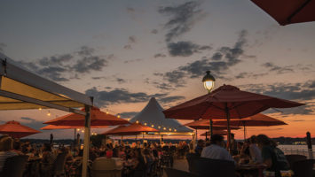 As daylight fades, patrons cozy up on the patio for the sun's extended bow.