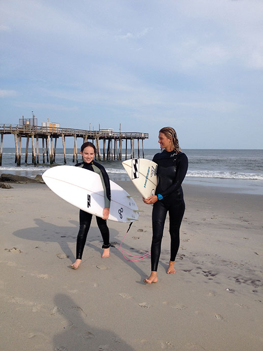 Pro surfer and instructor Cassidy McClain with student Ellie Pallidino on the beach in Margate.