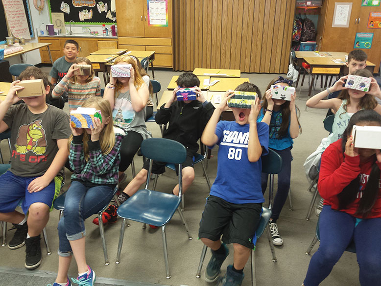 Fourth-graders at Washington Street Elementary School show off cardboard Google VR viewers scratch-built from pizza boxes.