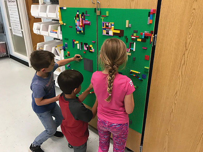 The recently installed makerspace Lego wall at East Dover Elementary School draws eager first-grade creative types.