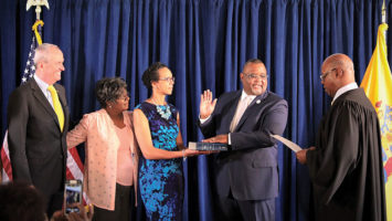 Judge Lawrence Lawson, right, swears in Lamont Repollet as the state's education commissioner, June 19 in Trenton. Holding the ceremonial Bible is the commissioner's wife, J. Darlene Repollet.