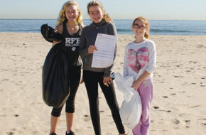 A trio of young volunteers filled a black bag with garbage and a white bag with recyclables at Clean Ocean Action's fall 2017 Beach Sweeps in Sea Bright. The card is used to record data.