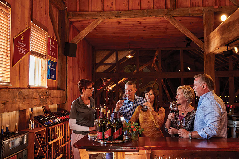 etsy Alger, left, leads Justin Cook, Xhoana Xhomara, and Pamela and Kevin Cook through a wine tasting at Unionville.