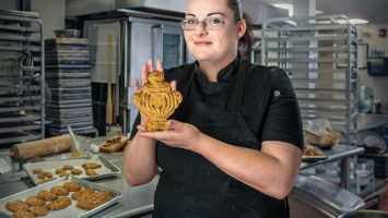 Susan Carter displays one of her namesake honeycakes, a honey-and-spice cookie. This one, a Russian pryaniki, takes the shape of a samovar.