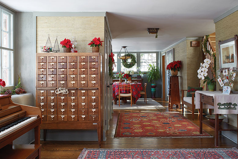 Furnishings reflect “the spirit of the home,” says Mathis, including the original card catalog acquired from the New York Times. The original front door is on the adjacent wall; the dining room just beyond.