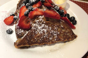 Brioche French toast dipped in custard, dusted with powdered sugar and served with fresh fruit