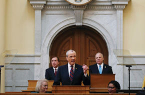 Assembly Speaker Craig J. Coughlin, left, and Senate President Steve Sweeney flank Governor Phil Murphy as he unveils his 2019 budget in the Assembly chamber.