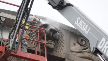 A pink granite lion outside of Newark Penn Station gets washed.